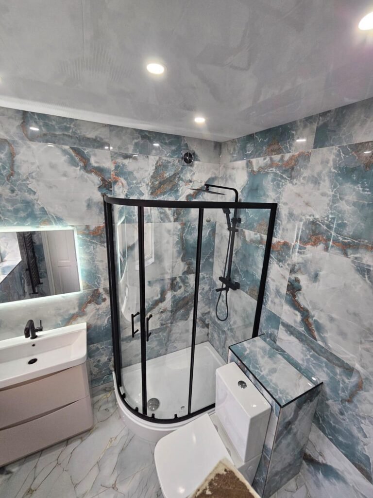 Stunning bathroom renovation featuring elegant marble-look tiles, a sleek shower enclosure, modern vanity, and a stylish toilet. Perfect for a luxurious and contemporary bathroom upgrade. Likely location: United Arab Emirates